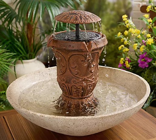 Decorative outdoor water fountain with a bowl in a garden setting