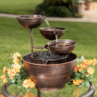 Bronze outdoor fountain with water flowing in a garden setting