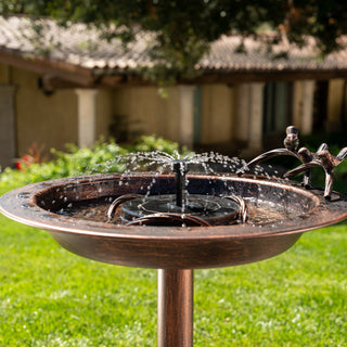 Outdoor garden water feature with solar pump on a grassy lawn