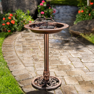 Decorative outdoor water fountain on a paved pathway with garden elements.