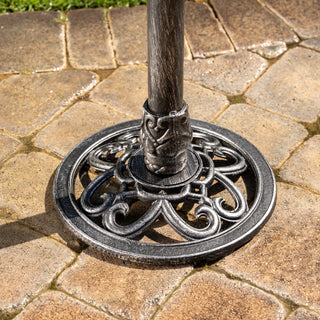 Decorative metal base of an outdoor umbrella on a stone patio