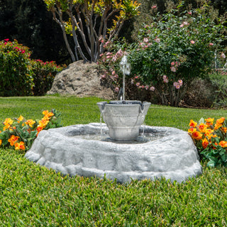 Garden fountain with flowers on a grassy lawn