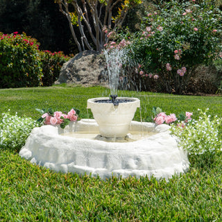 White stone fountain with water feature in a garden setting