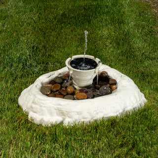 Small water fountain with rocks on a grassy area